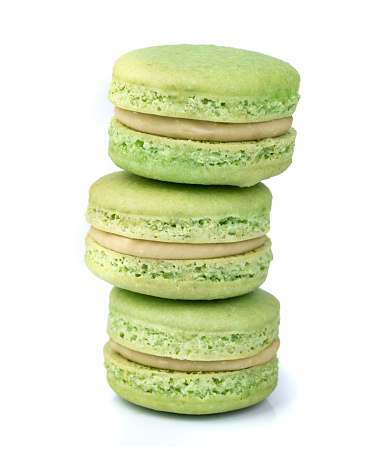 Pistachio macarons stacked isolated over white background.
