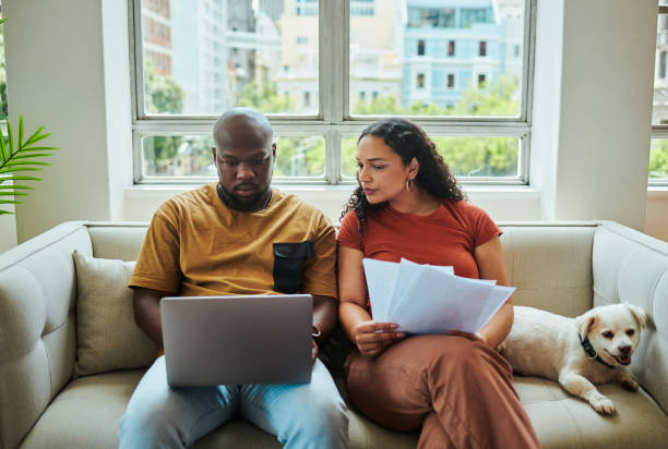 istock A young interracial couple working on their budget and finances on a sofa from home with their dog using a laptop computer 1502425493