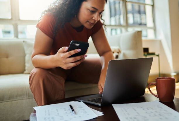 istock A young woman and her dog sitting on the sofa while working on her laptop computer and  mobile phone. Stock photo 1502425665