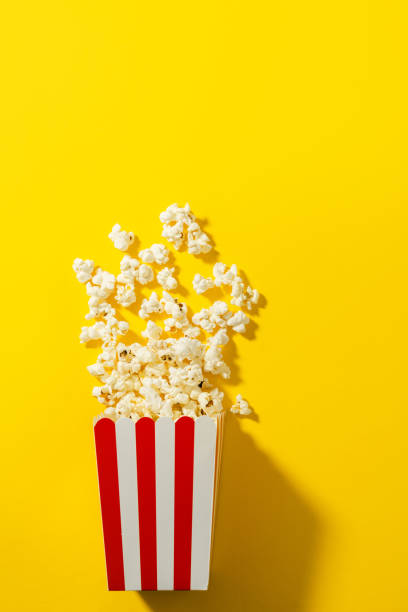 istock Classic striped bucket with delicious popcorn on  yellow background 1502425741
