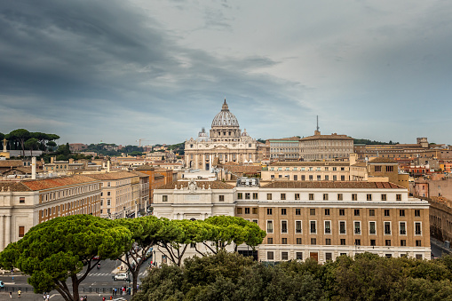 A suggestive and detailed view over the rooftops of Rome from the terrace of the Aventine hill, in the historic heart of the Eternal City. On the horizon the iconic domes of Sant'Andrea della Valle and Santi Biagio e Carlo ai Catinari churches, while in foreground the ancient Trastevere district. The Aventine hill, one of the seven historical hills of Rome, is one of the most visited places in the city due to the presence of tree-lined gardens, archaeological sites from the Roman era and some of the oldest churches in Rome from the Byzantine and medieval eras. In 1980 the historic center of Rome was declared a World Heritage Site by Unesco. Image in 16:9 and high definition format.