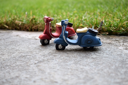 Miniature toy scooters on pavement