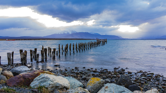 Long time exposure from the historical footbridge Muelle Historico with birds and dramatic clouds, Puerto Natales, Chile, Patagonia, South America