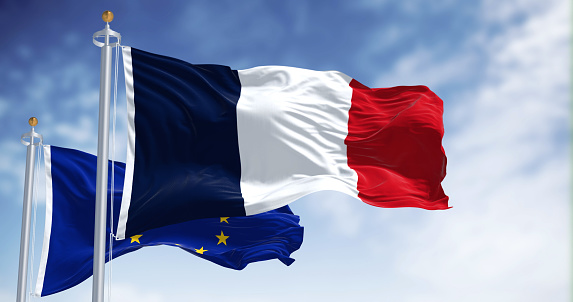 The flags of France and the European Union waving together on a clear day. France became a member of the European Union on January 1, 1958. 3d illustration render. Selective focus. Fluttering fabric
