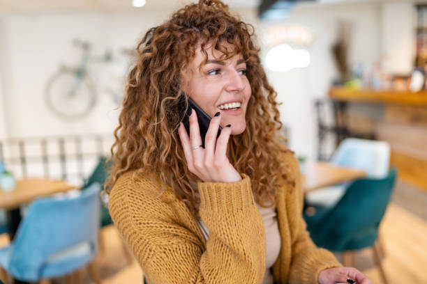 istock Young beautiful woman using mobile phone in modern coffee shop 1502435657