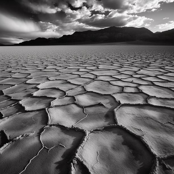 istock Desert with cracked earth featuring a cloudy sky above and mountains in the background 1502436284