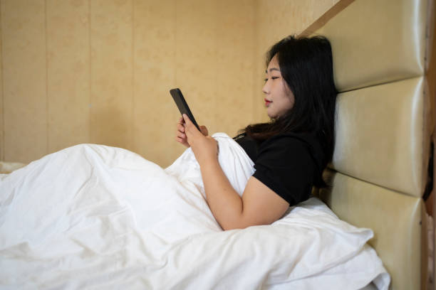 istock beautiful woman using smartphone in bed 1502438522