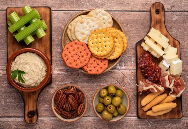 Food photography of appetizer, hummus and cheese Food photography of appetizer, hummus, celery, cracker, cheese, cheddar brie, salami, prosciutto, olives prosciutto brie stock pictures, royalty-free photos & images