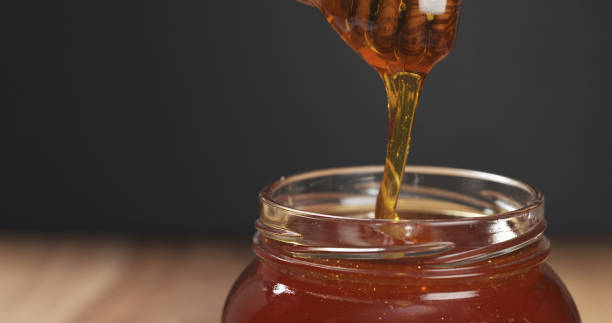 istock honey drips from dipper in glass jar 1502448302