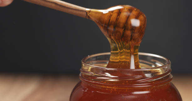 istock honey drips from dipper in glass jar 1502449376