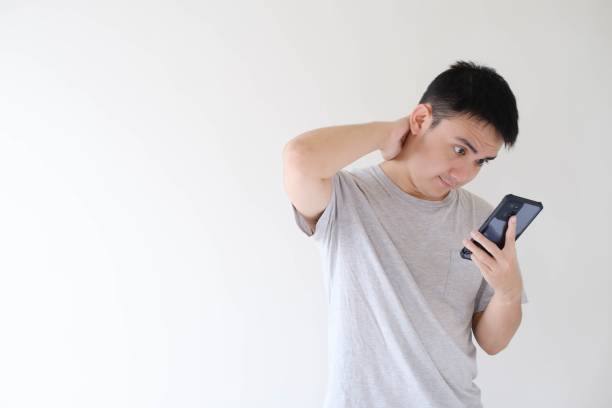 istock A young Asian man is shocked while holding and looking at a smartphone 1502450223