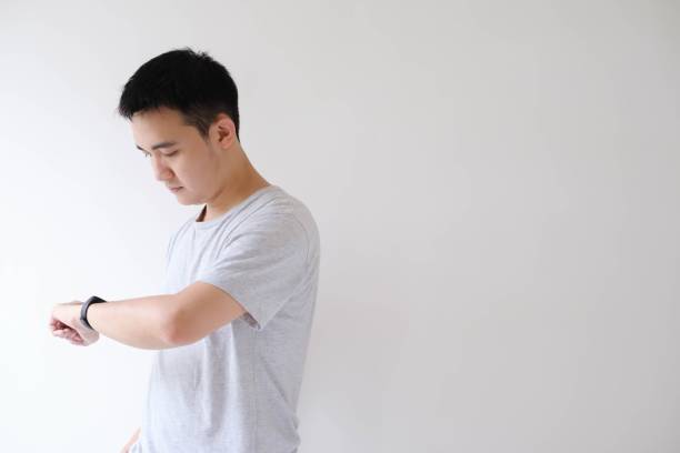 istock A young Asian man is checking the clock on a smartwatch on his left wrist 1502450225