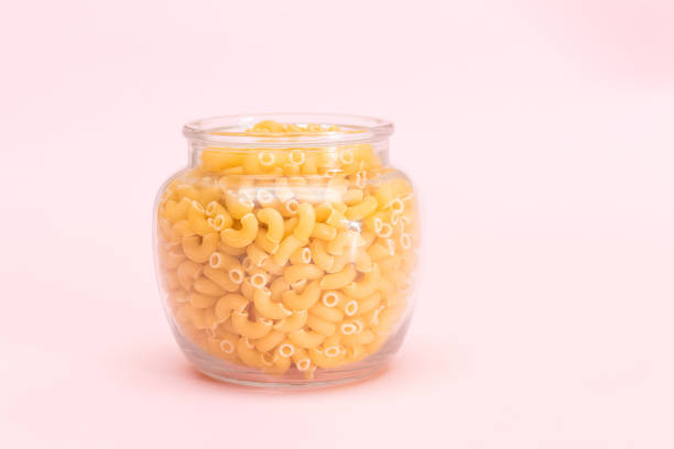 istock Uncooked Chifferi Rigati Pasta in Glass Jar on Pink Background 1502452267