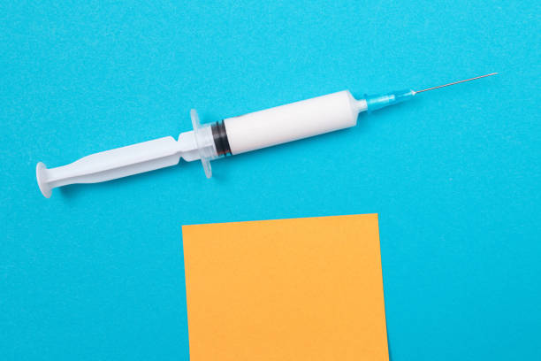 istock Vaccination or Revaccination Concept - A Medical Syringe on Blue Table 1502452412