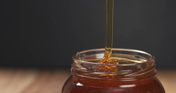 istock honey pour with spoon in glass jar 1502452481