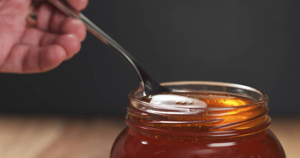 istock honey pour with spoon in glass jar 1502453032