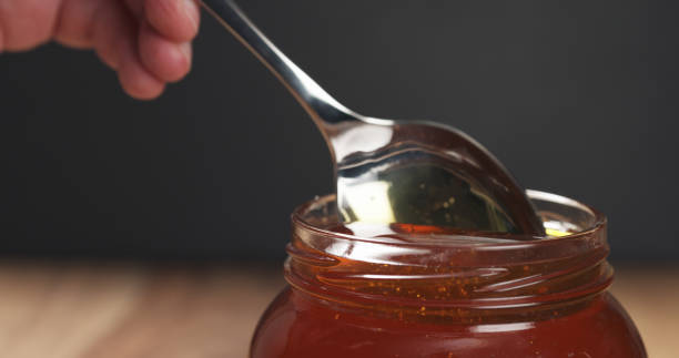 istock honey pour with spoon in glass jar 1502453085