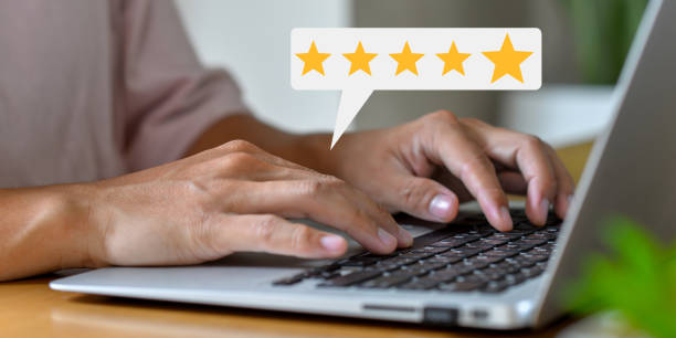 istock Customer using hand pressing keyboard on laptop with gold five star rating feedback icon and press level excellent rank for giving best score point to review the service , business concept 1502453738