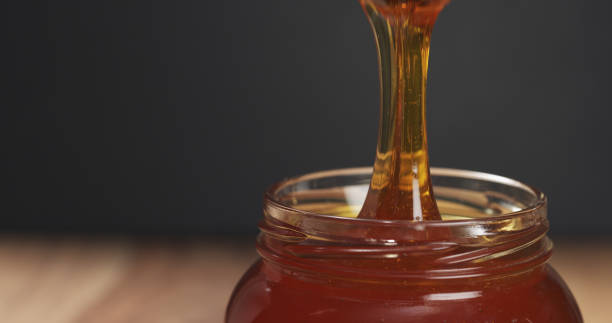 istock honey drips from dipper in glass jar 1502454304