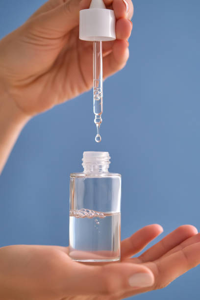 istock Serum with a pipette in female hands on a blue background. 1502454321