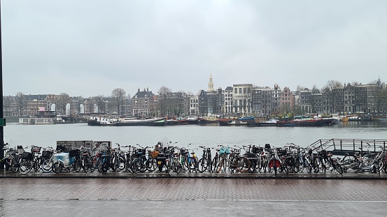 Amsterdam, Netherlands – March 21, 2023: Bicycles and traditional houses in the downtown of Amsterdam.