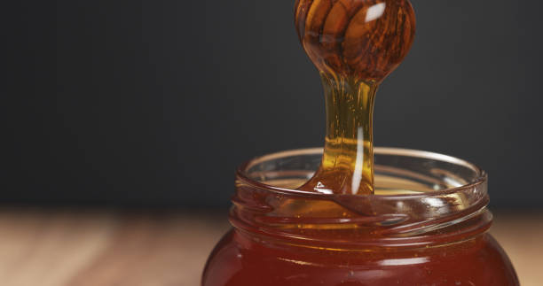 istock honey drips from dipper in glass jar 1502455045