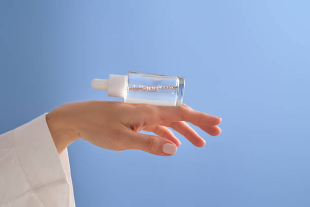 istock Serum with a pipette in female hands on a blue background. 1502455072