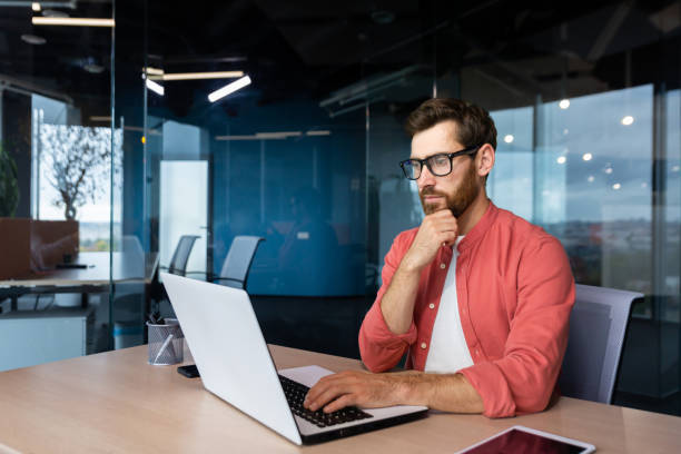 istock Thinking mature man with beard working with laptop inside office at workplace, businessman thinking about decision and future financial strategy. 1502456034