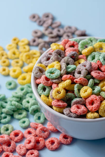istock White bowl with colorful ring-shaped cereal and milk on a blue background. 1502460046