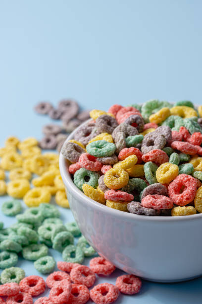 istock White bowl with colorful ring-shaped cereal and milk on a blue background. 1502460047
