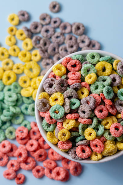 istock White bowl with colorful ring-shaped cereal and milk on a blue background. 1502460083