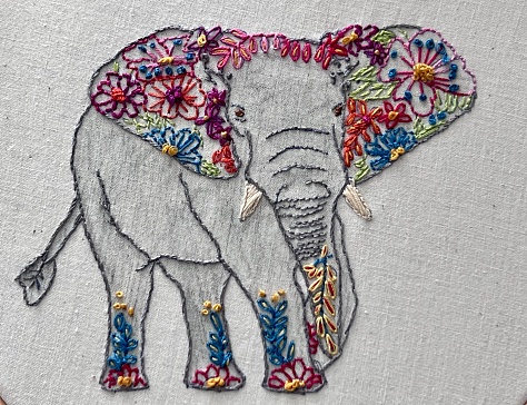 A hand drawn, coloured and embroidered African elephant. Stitched on to linen