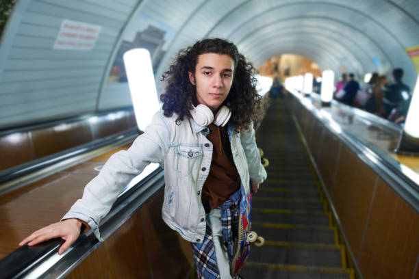 istock Serious teenage guy with skateboard looking at camera on escalator 1502461890
