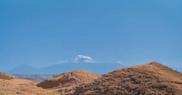 Photo of View from Arin Berd hill and Erebuni fortress to the majestic peak of snowy Ararat. Traveling to popular places, heritage of human history, idea for banner or postcard