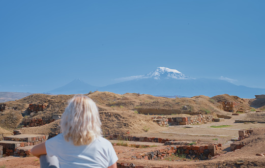 View from Arin Berd hill and Erebuni fortress to the majestic peak of snowy Ararat. Traveling to popular places, heritage of human history, idea for banner or postcard