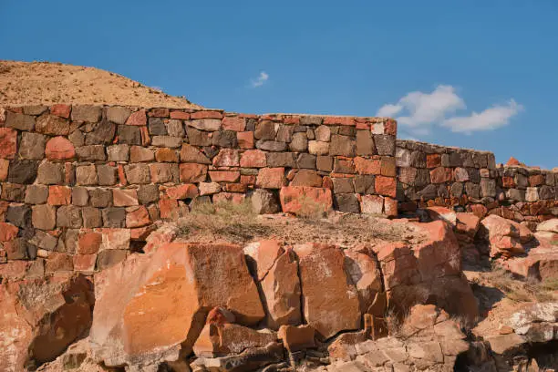 Photo of The ruins of the ancient fortress of Erebuni, the kingdom of Urartu in modern Yerevan, Armenia. Traveling to popular places, heritage of human history, idea for banner or postcard