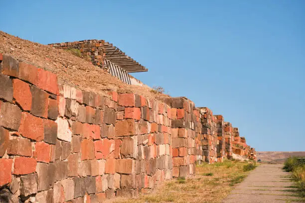 Photo of Restored walls of the ancient fortress of Erebuni, the kingdom of Urartu in present-day Yerevan, Armenia. Traveling to popular places, heritage of human history, idea for banner or postcard