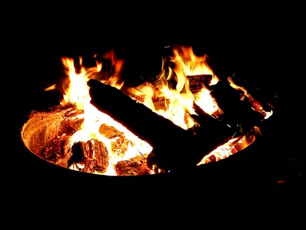 A blazing fire and crackling logs burning brightly in the darkness