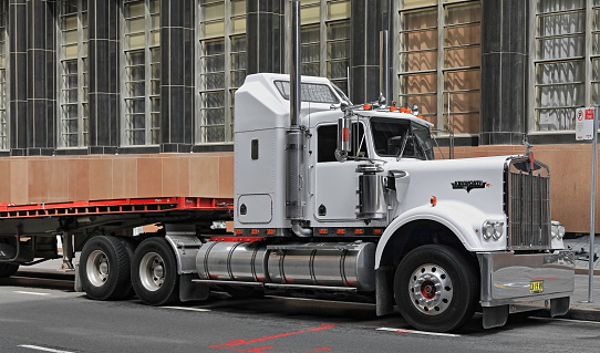 Sydney, Australia, October 17, 2018: Long semi-trailer trucks are allowed to drive well into the CBD and park on the streets to meet the heavy transportation needs of the area. Here on Pitt Street.