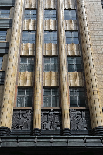 Facade of seven-storey, Art-Deco style building from AD 1939 displaying bas-relief panels above the entrance depicting the water industry's technological progression. Pitt Street-Sydney-NSW-Australia.