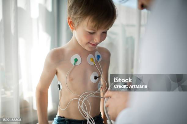 Doctor Adjusting Ecg Holter Monitor For A Child To Check His Heart Health Stock Photo - Download Image Now