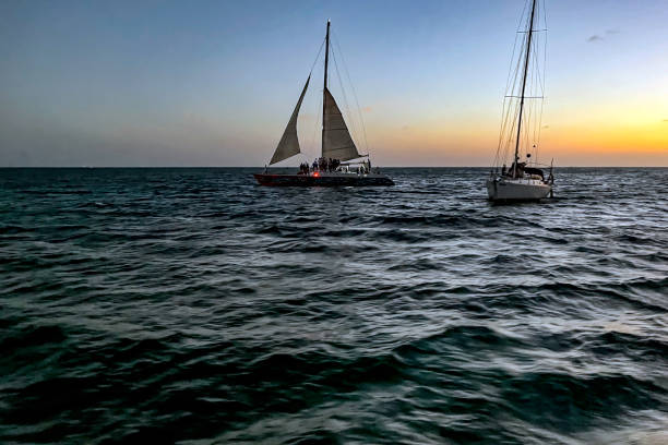 voiliers au large d’aruba offrant une croisière au coucher du soleil - sailing sailboat sunset aruba photos et images de collection