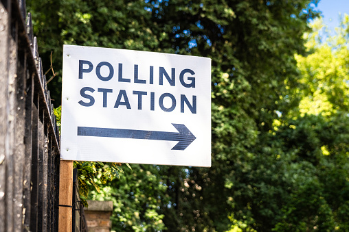 A sign directing voters towards a polling station.