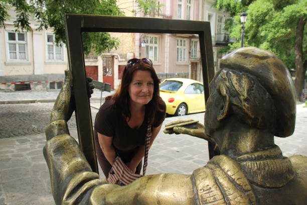 Woman framed for a portrait by a sculpture of an artist working on the streets of Plovdiv in Bulgaria stock photo
