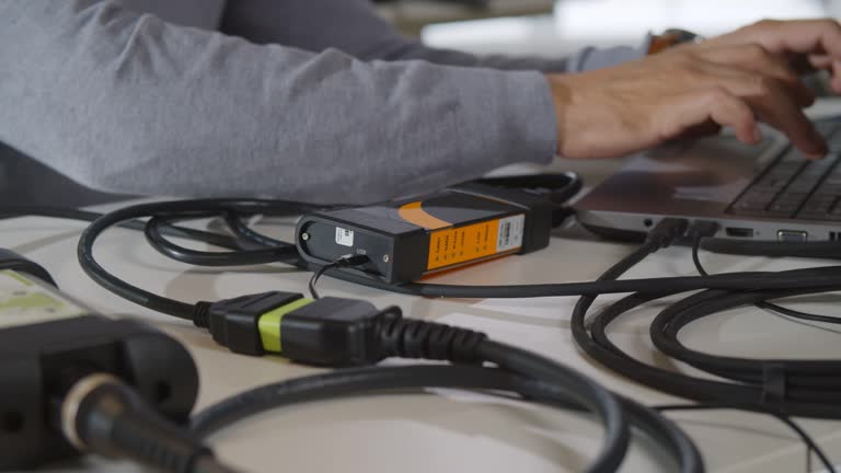 Cropped shot of male it-specialist connect wires to gadget and fix laptop