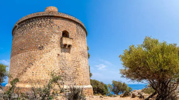 Ancient Torre Picada in Port de Sóller with its elevated entrance door, an enduring testament to the ingenuity of medieval architecture and a defense mechanism, ensuring that invaders remain outside.