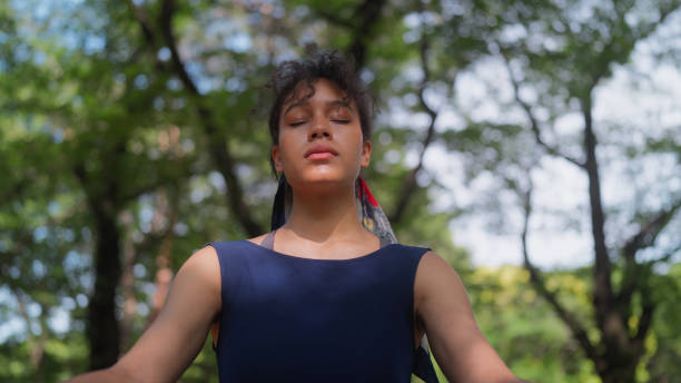 Young woman meditating in nature during group therapy session