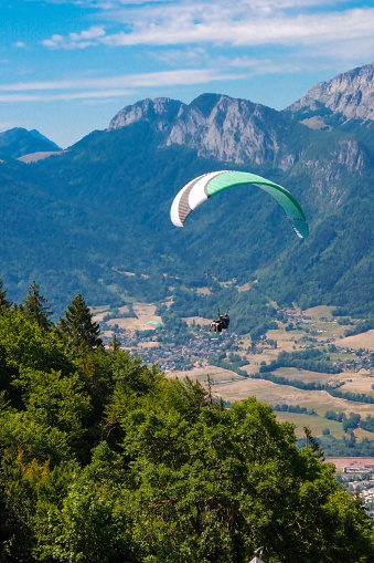 People paragliding near mountains.