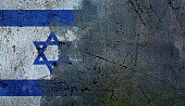Ominous times for Israel: national flag being erased from a scratched grungey concrete wall, with copy space