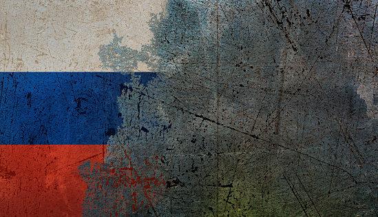 Serious times for Russia: painted national flag peeling off distressed plaster wall.